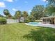 Lush backyard featuring a sparkling pool, green grass, and mature trees at 3325 Schefflera Rd, Tampa, FL 33618