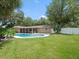 Spacious backyard featuring a refreshing pool, screened patio, and privacy fence at 3325 Schefflera Rd, Tampa, FL 33618