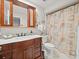 Well-lit bathroom featuring a dark wood vanity, a decorative mirror, and a seashell shower curtain at 3325 Schefflera Rd, Tampa, FL 33618