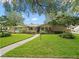 Charming single-story home featuring a well-manicured lawn, mature trees, and inviting front entry at 3325 Schefflera Rd, Tampa, FL 33618