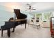 Open-concept living room with grand piano, large windows, and neutral-toned furniture at 3325 Schefflera Rd, Tampa, FL 33618