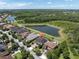 Scenic aerial view of the property with a serene lake, mature trees, and well-maintained landscaping at 3477 Barbour Trl, Odessa, FL 33556