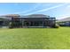 Beautiful backyard with a well-maintained lawn and a screened-in patio, perfect for relaxation and entertaining at 3477 Barbour Trl, Odessa, FL 33556
