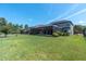 Expansive backyard featuring lush green grass, mature trees, and a screened lanai for outdoor enjoyment at 3477 Barbour Trl, Odessa, FL 33556