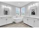 Luxurious bathroom featuring a freestanding tub, dual vanities, and elegant fixtures at 3477 Barbour Trl, Odessa, FL 33556