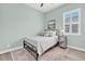 Bedroom featuring light green walls, neutral decor, rug, and a window with plantation shutters at 3477 Barbour Trl, Odessa, FL 33556
