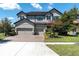 Stunning two-story home featuring a three-car garage, well-manicured landscaping, and a brick driveway at 3477 Barbour Trl, Odessa, FL 33556