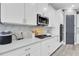 Bright kitchen with white cabinetry, stainless steel appliances, and a gray accent wall at 3477 Barbour Trl, Odessa, FL 33556