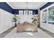 Stylish home office with blue accent wall, a wooden desk, and ample natural light at 3477 Barbour Trl, Odessa, FL 33556