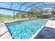 Stunning screened-in pool with a stone waterfall and a lake view at 3477 Barbour Trl, Odessa, FL 33556
