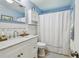 Bathroom featuring a white vanity with marble top, toilet, and shower behind curtain at 3545 59Th N Ln, St Petersburg, FL 33710
