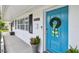 Detailed view of the home's bright blue front door adorned with a wreath and stylish accents at 3545 59Th N Ln, St Petersburg, FL 33710