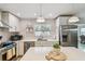 Well-lit kitchen with white cabinets, island seating, and stainless steel appliances for a modern feel at 3545 59Th N Ln, St Petersburg, FL 33710