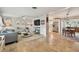 Open-concept living space with travertine floors connecting to a well-lit kitchen and dining area at 3545 59Th N Ln, St Petersburg, FL 33710
