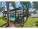 A screened-in pool area boasts ample space for outdoor dining and entertaining, including a grill and umbrella table at 3545 59Th N Ln, St Petersburg, FL 33710