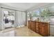 Sun room featuring travertine tile, large window, vintage bureau and access to patio at 3545 59Th N Ln, St Petersburg, FL 33710