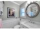Bathroom featuring wainscoting, a round mirror, and bright finishes at 3898 49Th S Ave, St Petersburg, FL 33711
