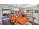 Open-concept dining area with large table, chandelier, and views to the living room and decorative display shelves at 3898 49Th S Ave, St Petersburg, FL 33711