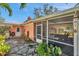 Home exterior featuring a screened-in patio, plants and a stone walkway at 3898 49Th S Ave, St Petersburg, FL 33711