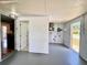 Spacious basement area featuring painted walls, utility access, and doorway to kitchen, ready for customization at 3902 Glissade Dr, New Port Richey, FL 34652