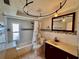 Bright bathroom features tile floors and walls, matching wood vanity, and shower with tub at 3902 Glissade Dr, New Port Richey, FL 34652