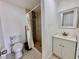 Bright bathroom featuring a shower with decorative tiling, a toilet, and a vanity with a mirror at 3902 Glissade Dr, New Port Richey, FL 34652