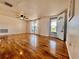 Bright living room with wood flooring, a ceiling fan, and a view of the outdoors at 3902 Glissade Dr, New Port Richey, FL 34652