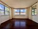 This large living room features hardwood flooring and several windows allowing lots of natural light at 3902 Glissade Dr, New Port Richey, FL 34652