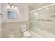Well lit bathroom with modern tiled shower and a square mirror at 3928 E Eden Roc Cir, Tampa, FL 33634