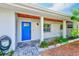 Home's front entrance featuring a bright blue front door and brick details at 3928 E Eden Roc Cir, Tampa, FL 33634