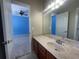 Bathroom featuring a marble countertop, wood cabinets, and a large mirror, creating a warm, inviting space at 405 Islebay Dr, Apollo Beach, FL 33572