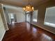 Spacious dining room with gleaming hardwood floors, chandelier, and large windows providing ample natural light at 405 Islebay Dr, Apollo Beach, FL 33572