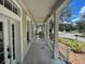 Inviting front porch with white railings and columns, offering a comfortable outdoor space and neighborhood view at 405 Islebay Dr, Apollo Beach, FL 33572