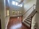 Open-concept living room with hardwood floors, high ceilings, and a staircase leading to the upper level at 405 Islebay Dr, Apollo Beach, FL 33572
