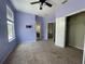 Carpeted main bedroom features a ceiling fan, walk-in closet, and view into ensuite bath and additional room at 405 Islebay Dr, Apollo Beach, FL 33572