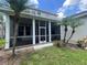 View of the screened porch and backyard framed by two palm trees, enhances outdoor living experience at 405 Islebay Dr, Apollo Beach, FL 33572
