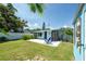 Backyard featuring a patio, outdoor shower, lush green lawn, tropical landscaping, and a white privacy fence at 4718 24Th S Ave, St Petersburg, FL 33711