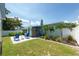 Backyard featuring a patio, outdoor shower, lush green lawn, tropical landscaping, and a white privacy fence at 4718 24Th S Ave, St Petersburg, FL 33711