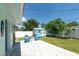 Backyard view of a brick patio, shed with mural, Adirondack chairs, manicured lawn and white fence at 4718 24Th S Ave, St Petersburg, FL 33711
