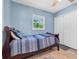 A cozy bedroom with a single bed, light blue walls, and a window with a view of green tropical foliage at 4718 24Th S Ave, St Petersburg, FL 33711