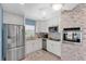 Bright kitchen featuring stainless steel appliances, white cabinets, and a stylish tile backsplash at 4718 24Th S Ave, St Petersburg, FL 33711