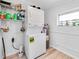 Stackable washer and dryer with overhead shelving in a compact laundry area, including a water heater at 4718 24Th S Ave, St Petersburg, FL 33711