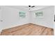 Bright bedroom featuring hardwood floors, a ceiling fan, and two windows providing ample natural light at 4731 W Leila Ave, Tampa, FL 33616