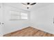 Bright bedroom featuring hardwood floors, a ceiling fan, and two windows providing ample natural light at 4731 W Leila Ave, Tampa, FL 33616