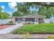 Charming home featuring well-manicured lawn, landscaped garden beds, and a screened-in porch at 4731 W Leila Ave, Tampa, FL 33616