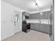 This well-lit kitchen features stainless steel appliances, gray cabinets, and tile flooring at 4731 W Leila Ave, Tampa, FL 33616
