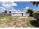 Spacious backyard of the home showcases the exterior, trees, and sunny skies offering a serene outdoor space at 4823 Ashland Dr, Tampa, FL 33610