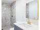 Updated bathroom with gray tile shower, modern vanity and sink, and gold fixtures at 4823 Ashland Dr, Tampa, FL 33610