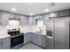 Renovated kitchen featuring gray cabinets, stainless steel appliances, and stone countertops and backsplash at 4823 Ashland Dr, Tampa, FL 33610