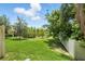 A lush green backyard with a black iron fence and mature trees, perfect for outdoor enjoyment at 5110 Sylvester Loop, Tampa, FL 33610